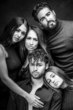 a group of people posing for a black and white photo with their arms around each other