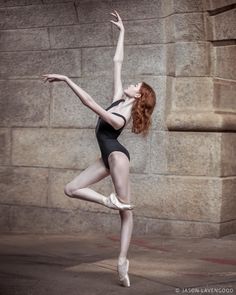 a woman in black leotard and white ballet shoes is doing a dance pose