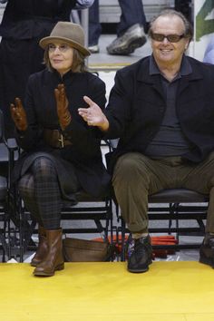 an older man and woman sitting next to each other at a basketball game