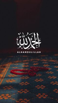 an arabic calligraphy is displayed on the carpet in front of a dark background with red beads