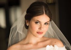 a woman in a wedding dress with a veil on her head