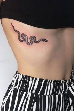 a woman's stomach with a snake tattoo on her left side ribcage