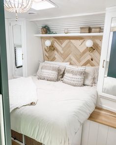 a white bed sitting in a bedroom next to a wooden headboard and window sill