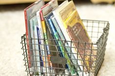 a metal basket filled with books on top of a carpet