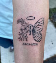 a small tattoo on the leg of a woman with flowers and a butterfly in it