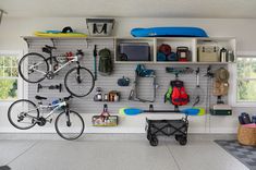 a garage with two bikes and several surfboards on the wall