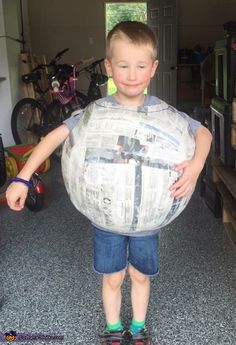 a young boy is holding a large inflatable ball