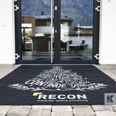 an entrance mat with the words recon printed on it in front of a building