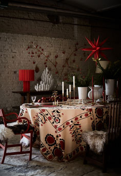 a dining room table covered with a cloth and decorated with red starbursts