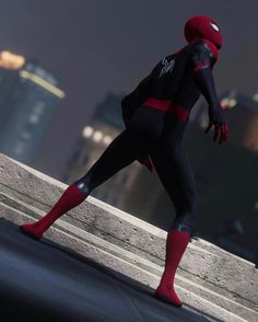 a spider - man standing on top of a cement wall