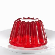 a red jelly cake sitting on top of a white plate