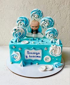 a blue and white cake with an image of a baby in the center surrounded by swirls