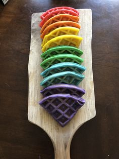 a wooden spoon with different colored waffles on it