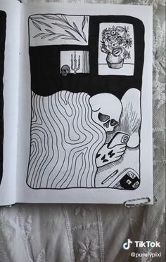 an open book with black and white drawings on it's cover, sitting on a bed