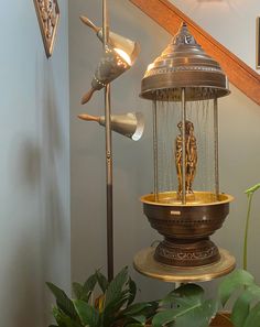 a bird feeder sitting on top of a wooden table next to a potted plant