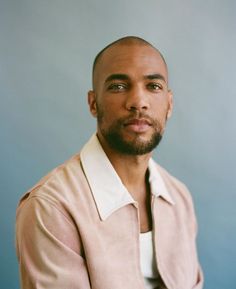 a close up of a person wearing a pink shirt and white collared dress shirt