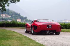 a red sports car parked on top of a gravel road