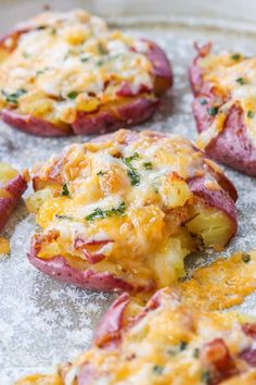 baked potatoes covered in cheese and herbs on a baking sheet