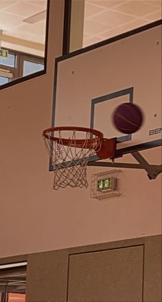 a basketball going through the hoop in an indoor gym