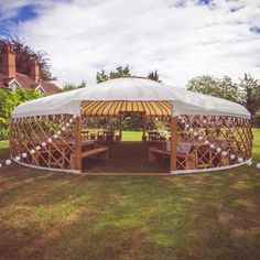 a large white tent sitting on top of a lush green field