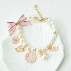 a white shell with pink and gold charms on it