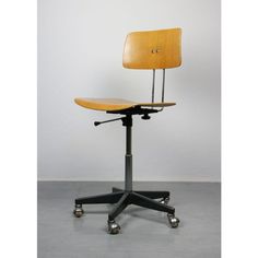 an office chair sitting on top of a metal casteor wheel with a wooden seat