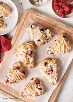 several pastries on a tray with raspberries in the background