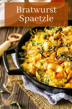 a skillet filled with pasta and vegetables on top of a wooden table