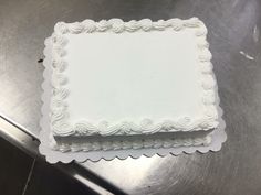 two square white cakes sitting on top of a table