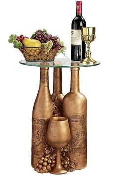 two wine bottles are sitting on a glass table with a bowl of grapes and a bottle of wine next to it