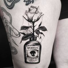 a black and white photo of a woman's thigh with a tattoo on it