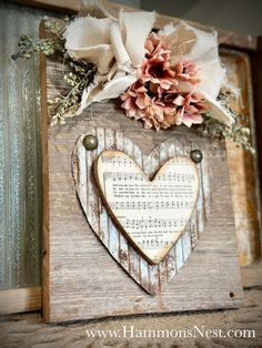 a wooden sign with music sheets and flowers on it