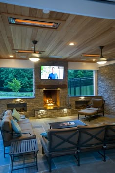 a living room with couches, chairs and a flat screen tv on the wall