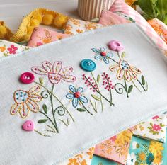 a close up of a piece of cloth with flowers on it and buttons in the middle