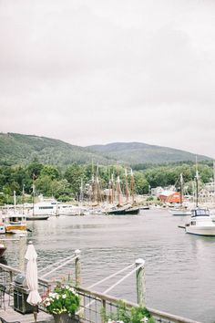 boats are docked in the water near a dock with benches and umbrellas on it