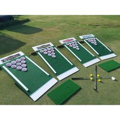 several different types of golf practice equipment laid out on the grass with markers, tees and balls