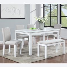 a white dining table with four chairs and a bench