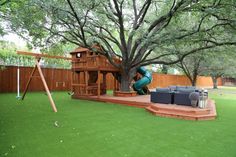 a backyard with a swing set, slide and play structure in the middle of it