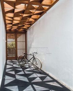 a bicycle is parked on the side of a building with wooden slats covering it