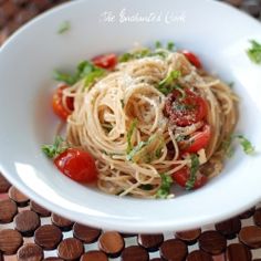 a white bowl filled with pasta and tomatoes