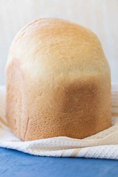 a loaf of bread sitting on top of a blue cloth next to a white towel