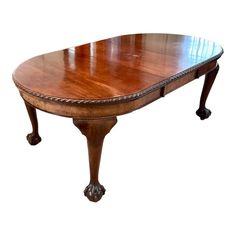 an oval wooden table with two leaves on one end