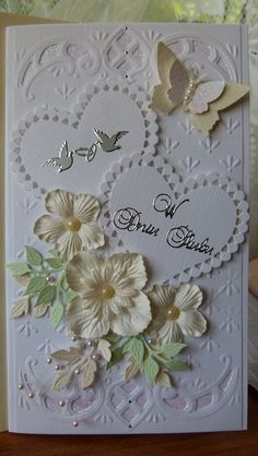 a close up of a card with flowers and butterflies on the front, in white