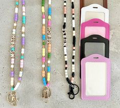 three lanyards with cell phones attached to them and some keychains on the ground