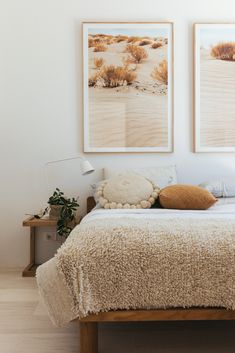 a bed with two pictures hanging on the wall above it