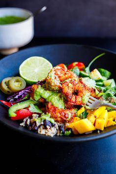 a black plate topped with meat and veggies