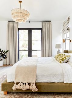 a bedroom with a large bed and chandelier