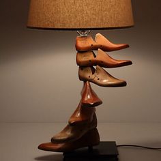 a lamp made out of wooden shoes on a table next to a light fixture with a brown shade