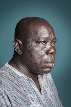 an older man with wrinkles on his face and neck, looking at the camera