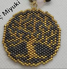 a beaded key chain with a black and yellow circle on it's side